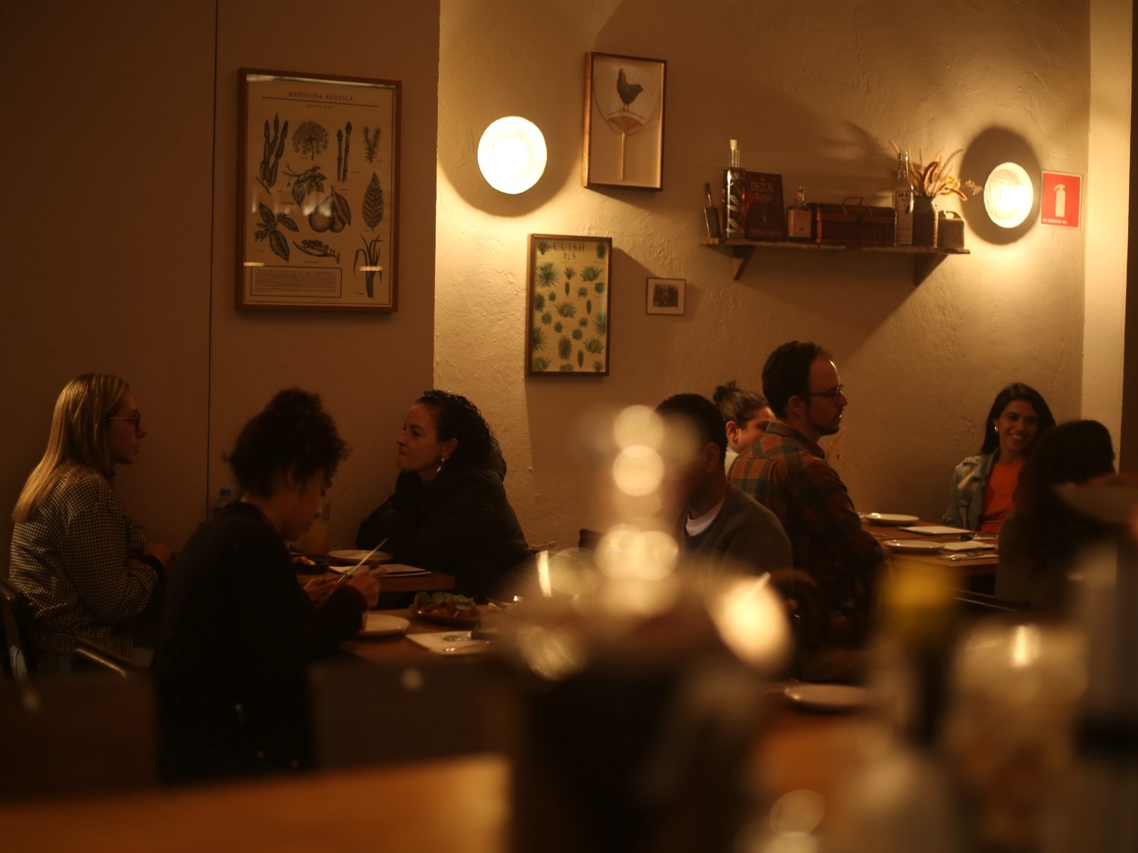 Restaurante movimentado à noite, mesas cheias de clientes conversando